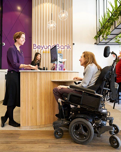 Beyond Bank staff member serving a customer in a wheelchair