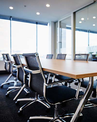 A board room table with eight chairs around it