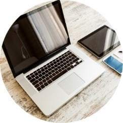 A laptop and a tablet on a wood table