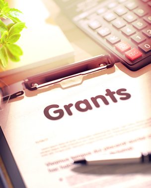 The word Grants in bold lettering on a page attached to a clipboard