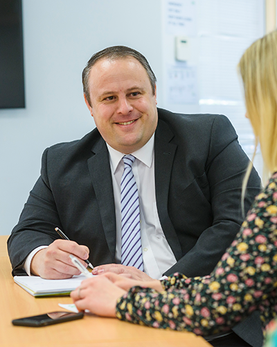 An image of Andrew Ellis in conference with a client