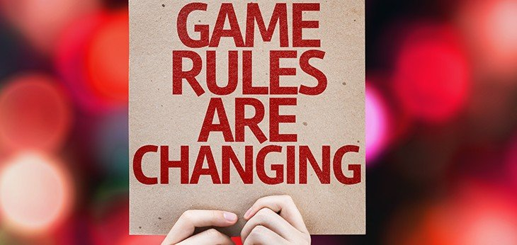 a pair of hands holding up a sign saying game rules are changing