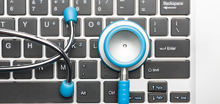 laptop keyboard with blue stethescope resting on it