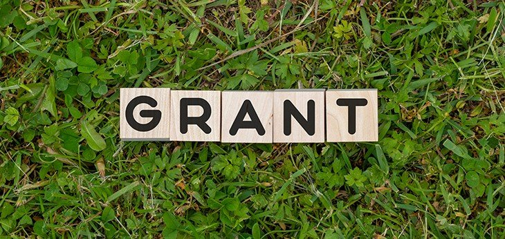 Wooden tiles spelling out the word grant on a background of green grass