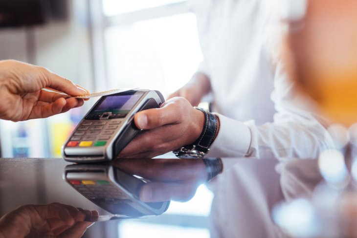 person making a purchase with a credit or debit card using an EFTPOS machine