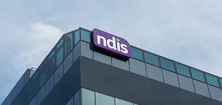 a glass building with an ndis sign on the corner