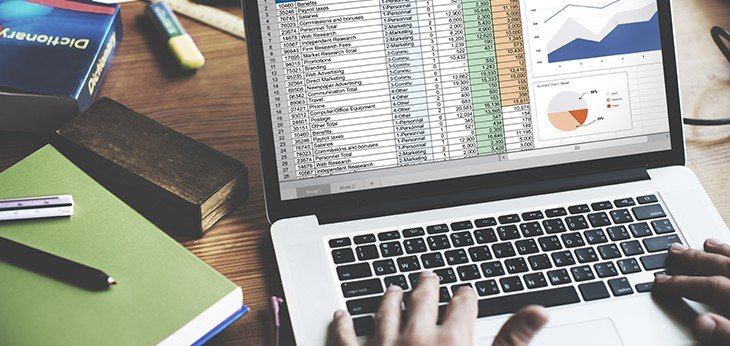an image of someone using a laptop working on a spreadsheet